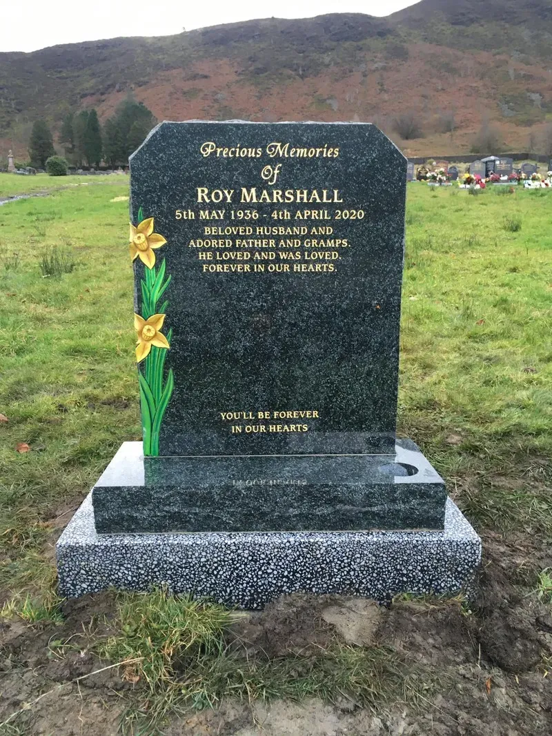 Dark grey granite headstone with an ogee top, hand-painted daffodil and gold leaf inscription on a silver grey base by FR Terrazzo, Rhondda Cynon Taff