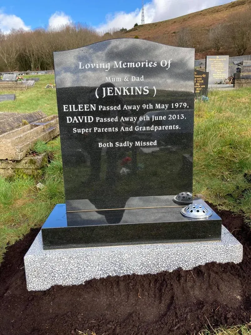 Low profile black granite wedge memorial with gold leaf lettering on a light grey base by FR Terrazzo