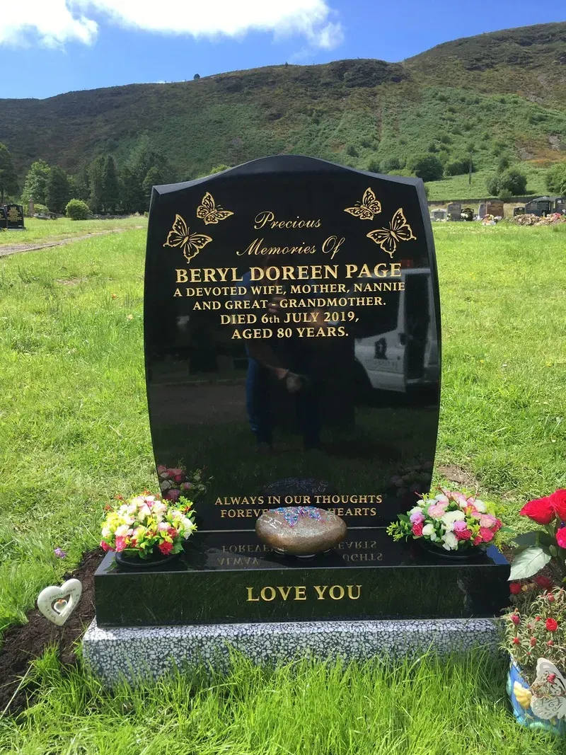 Black granite headstone with gilded butterflies, gold leaf inscription and a lettered kerb front by FR Terrazzo, Rhondda Cynon Taff