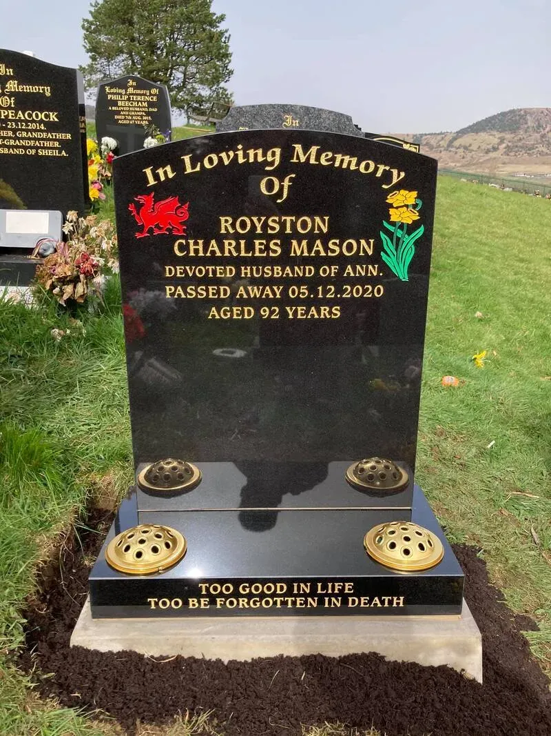 Black granite headstone with a hand-painted Welsh dragon and daffodil beside gold leaf lettering by FR Terrazzo