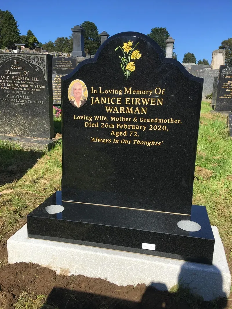 Black granite headstone with a ceramic photograph inset and hand-painted daffodils by FR Terrazzo, Rhondda Cynon Taff