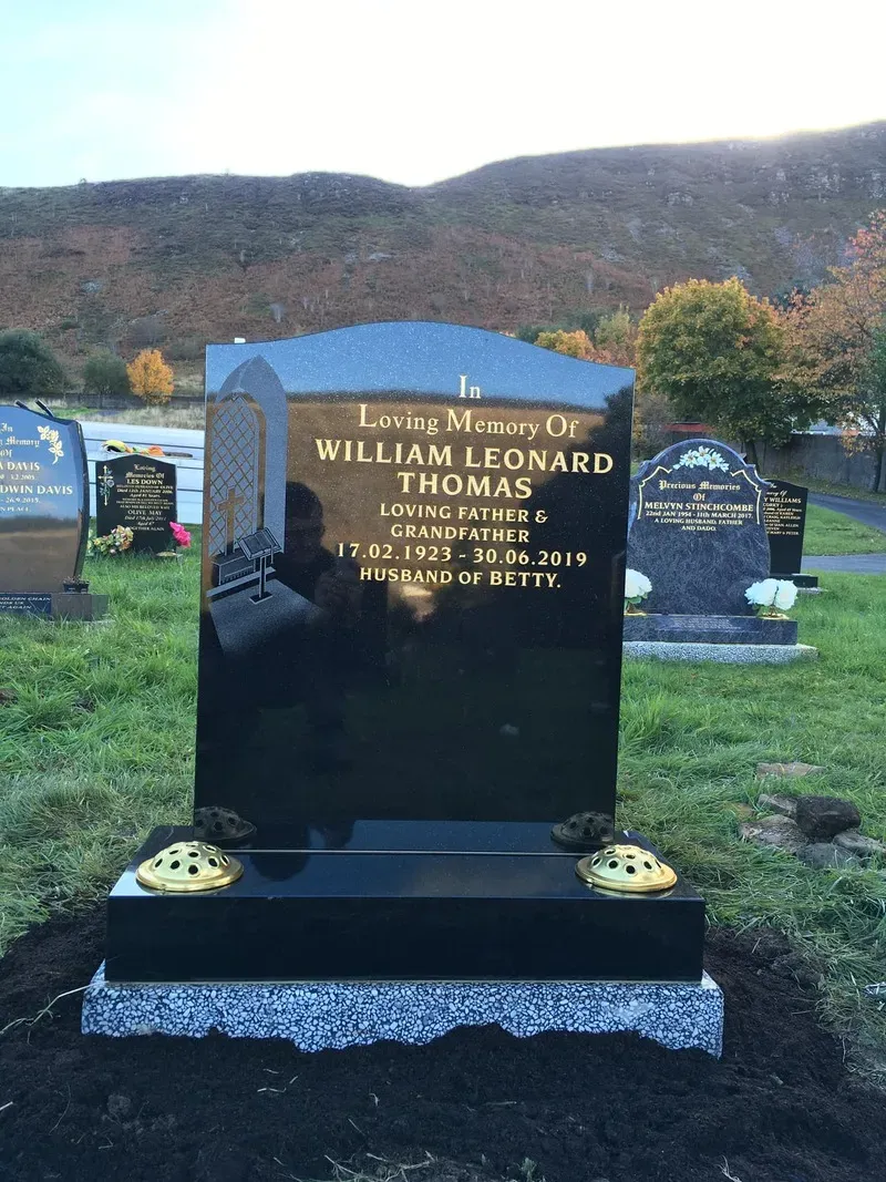 Black granite round-top headstone with gold leaf lettering and a polished granite base by FR Terrazzo, Rhondda Cynon Taff