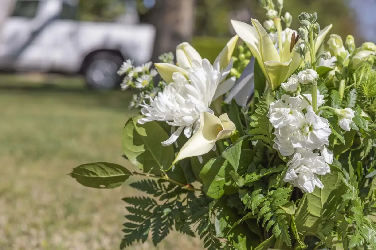 White flowers in a vase at a graveside in Rhondda Cynon Taff